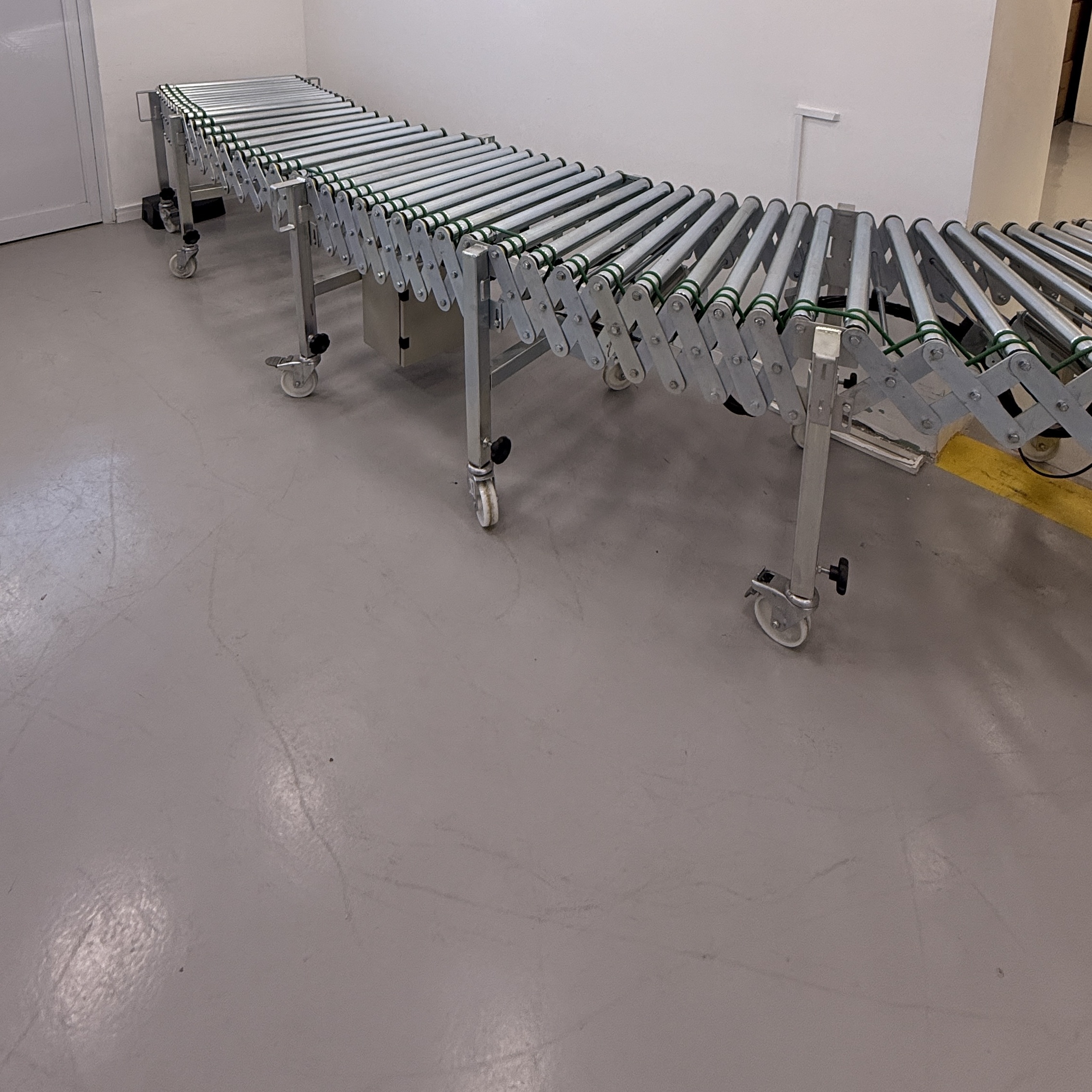 Detalhe dos roletes e transmissão de uma esteira flexível motorizada